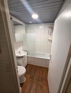 a bathroom with a toilet and a tub and a sink at Fewo GüNi Ostseeblick Wendtorf Marina Strand in Wendtorf