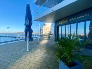 a blue umbrella sitting outside of a building at Fewo GüNi Ostseeblick Wendtorf Marina Strand in Wendtorf +11 photos