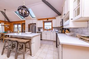 a kitchen with white cabinets and a large island at Duck Diamond - Sanderling, Ocean View, 95 Yds to Beach, Hot Tub, Sauna, Community Pool in Duck