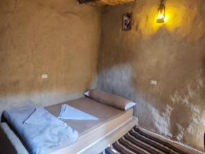 a small bed in a corner of a room at Historical Mayor's House in Qasr Al Farafirah