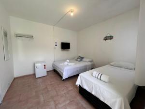 a room with two beds and a tv in it at Pé na Villa in Itacaré