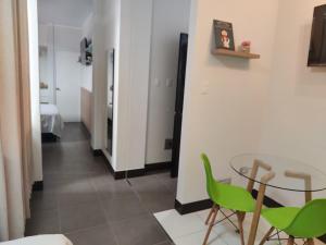 a dining room with a glass table and green chairs at Hospedaje Bry Ker in Pichanaki
