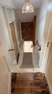 a room with a hallway with a door and a stairway at Beehive Cottage in Beccles +46 photos