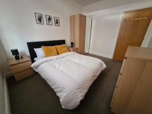 a bedroom with a bed with a white comforter at The Cossy Nook in Bolton