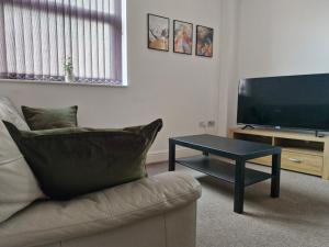 a living room with a couch and a coffee table at The Cossy Nook in Bolton