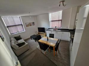 a small living room with a table and a kitchen at The Cossy Nook in Bolton +19 photos