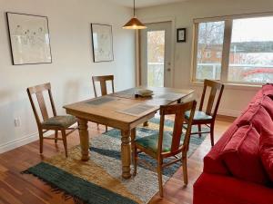 a dining room table with chairs and a red couch at Aurora views from 2 br apartment by lake in Yellowknife