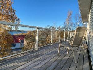 a chair sitting on the deck of a house at Aurora views from 2 br apartment by lake in Yellowknife +22 photos