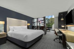 a hotel room with a bed and a desk and a computer at Courtyard by Marriott Oxford in Oxford