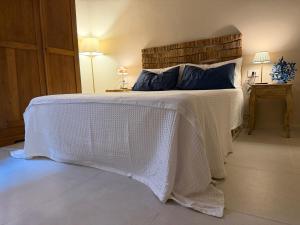 a bedroom with a white bed with blue pillows at Porto 24 in Portoferraio