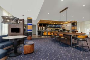 a lobby with tables and chairs and a kitchen at Courtyard by Marriott Oxford in Oxford