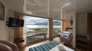 a room with a large window with a view of the water at Hotel Rocamonti in Aquitania