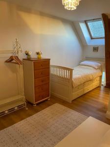 a bedroom with a bed with a dresser and a window at The Old Farm Gite in Amfreville
