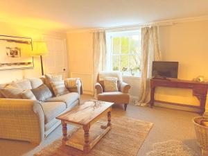a living room with a couch and a table at Beehive Cottage in Beccles