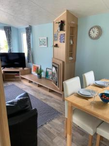 a living room with a table and a dining room at Park Home in Watchet