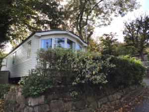 a small white house behind a stone wall at Park Home in Watchet