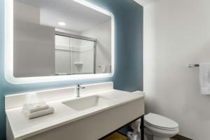 a white bathroom with a sink and a mirror at StudioRes by Marriott Jacksonville Orange Park in Orange Park +30 photos