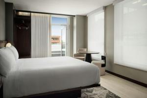 a bedroom with a large white bed and a window at AC Hotel by Marriott Burlington in Burlington +35 photos