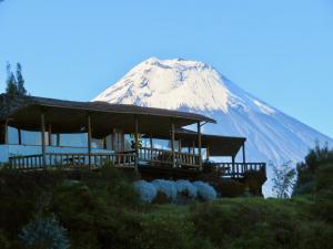 a snow covered mountain with a building in front of it at Patate Heights in Hacienda El Carmen +38 photos