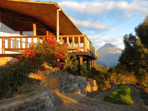 a building with flowers on the side of a mountain at Patate Heights in Hacienda El Carmen