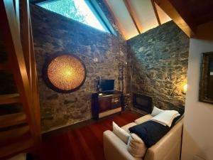 a living room with a couch and a window at Palheiros do Serrado by Real Vision in Estreito da Calheta