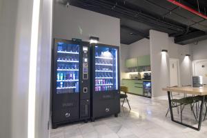 a drink vending machine in a room with a table at Hostel Superlativo Trinidad in Málaga
