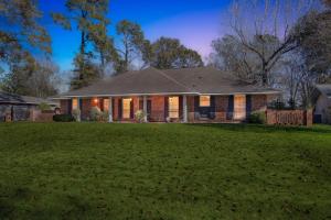 a house with a lawn in front of it at Rustic Retreat 5-BR Home with Backyard Oasis in Baton Rouge