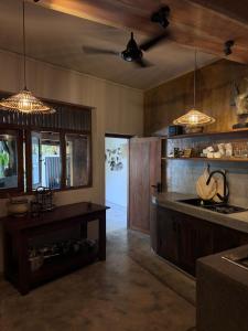 a kitchen with a counter and a table with lights at Tara Luxury House in Habaraduwa Central