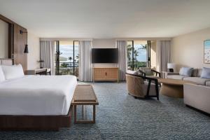 a hotel room with a bed and a living room at Waikoloa Beach Marriott Resort & Spa in Waikoloa