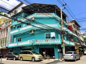 un edificio azul con coches estacionados frente a él en Urban Hostel Bangkok, en Bangkok