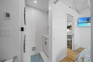 a white room with a bed and a bathroom at Private Cottage on Annie in Coeur d'Alene