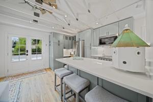 a kitchen with a large white counter and stools at Private Cottage on Annie in Coeur d'Alene +6 photos
