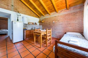a kitchen with a table and a refrigerator in a room at El Encuentro Casa de Campo in Río Cuarto