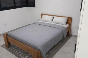 a bed in a white room with a wooden frame at Casa Serena in Capitán Bermúdez