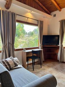 a bedroom with a bed and a desk and a window at Luminosa Patagónia in Lago Puelo