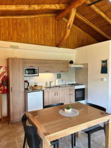 a large kitchen with a wooden table and chairs at Luminosa Patagónia in Lago Puelo