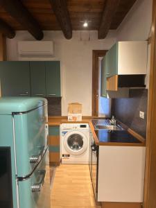 a kitchen with green cabinets and a washing machine at Teatro Vecchio 11 in Bassano del Grappa