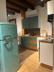 a kitchen with green cabinets and a refrigerator at Teatro Vecchio 11 in Bassano del Grappa
