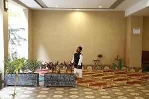 a man is standing in a room with plants at Ilva Hotel in Lahore
