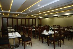 a dining room with tables and chairs in a room at Ilva Hotel in Lahore