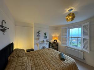 a bedroom with a large bed and a window at Harbour Retreat Cottage 3 bedroom in Poole