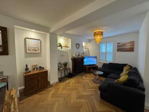 a living room with a couch and a television at Harbour Retreat Cottage 3 bedroom in Poole