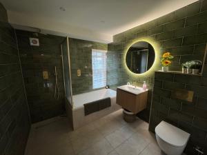 a bathroom with a tub and a sink and a toilet at Harbour Retreat Cottage 3 bedroom in Poole +60 photos