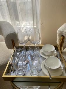 a tray with glasses and plates on a table at Andisa Airport Escape in Kempton Park