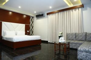 a hotel room with a bed and a couch at Ilva Hotel in Lahore +57 photos