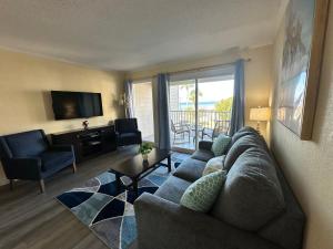a living room with a couch and a television at This could be your view every night of your stay!! Cozy, comfy remodeled condo! in Tampa