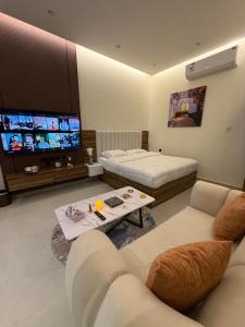 a living room with two beds and a tv at Nafel Modern Suite in Riyadh