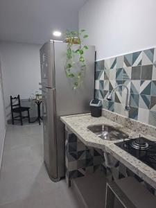 a kitchen with a stainless steel refrigerator with a potted plant at Apartamento Brisa do Mar - Casas confortáveis para casal e acompanhantes com garagem in Búzios