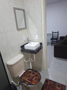 a bathroom with a sink and a toilet at Apartamento Brisa do Mar - Casas confortáveis para casal e acompanhantes com garagem in Búzios