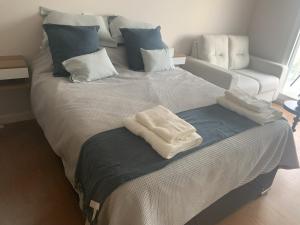 a large bed with two towels on top of it at Punta Carretas Vista al Mar in Montevideo